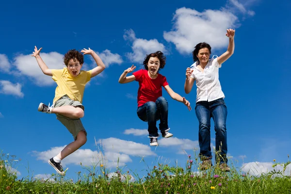 Familia activa - madre e hijos corriendo, saltando al aire libre — Foto de Stock