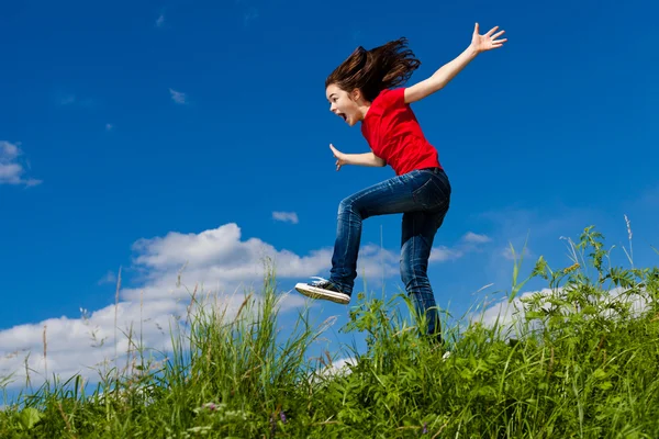 Dziewczyna skacze, działa przeciw błękitne niebo — Zdjęcie stockowe