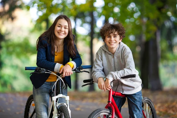 Urban biking - teens riding bikes in city park — Stock Photo, Image