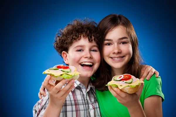 Kinderen eten grote broodjes — Stockfoto