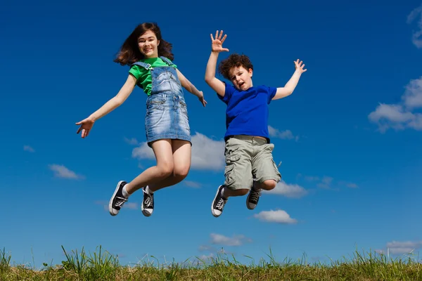 Mädchen und Junge rennen, springen im Freien — Stockfoto