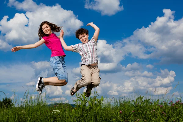 Girl and boy running, jumping outdoor — Stock Photo, Image