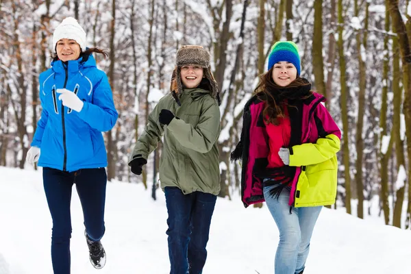 Familia activa - madre e hijos corriendo al aire libre en el parque de invierno —  Fotos de Stock