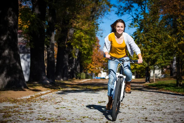 骑自行车在城市公园的女孩 — 图库照片
