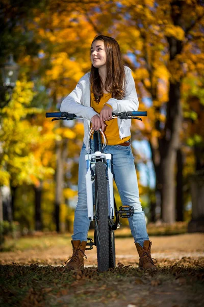 Menina de bicicleta no parque da cidade — Fotografia de Stock