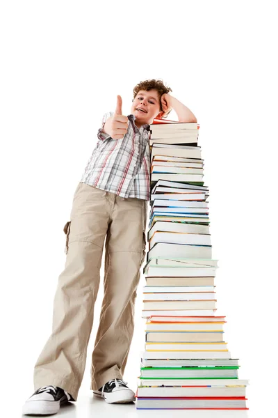 Studente in piedi vicino alla pila di libri su sfondo bianco — Foto Stock