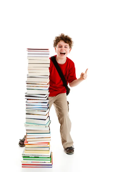 Студент, стоящий рядом с грудой книг на белом фоне — стоковое фото