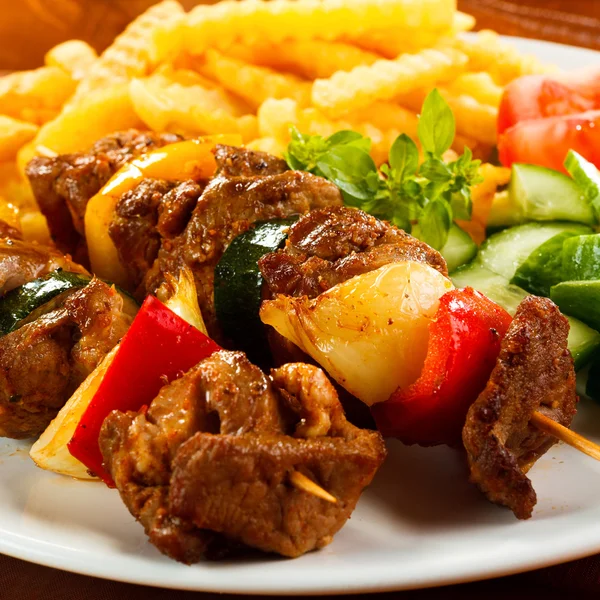 Carne grelhada, batatas fritas e legumes — Fotografia de Stock