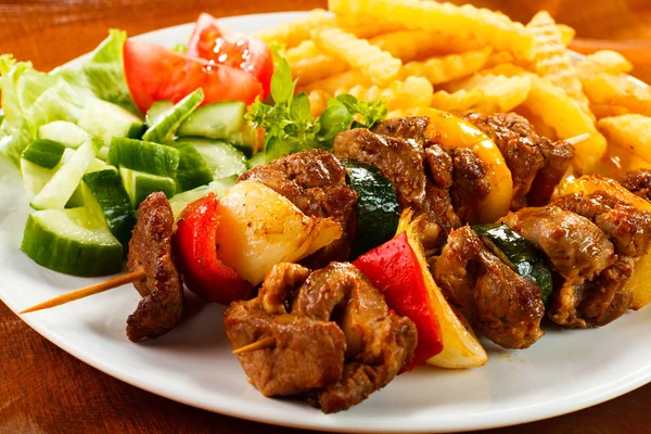 Жареное мясо, картофель фри и овощи — стоковое фото