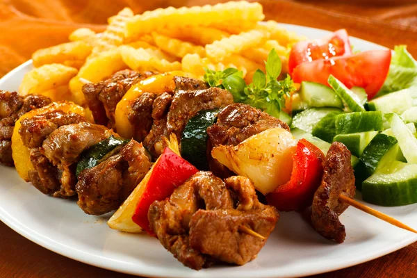 Смажене м'ясо, картопля фрі та овочі — стокове фото