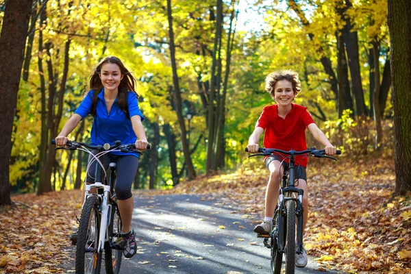 Ciclismo urbano - adolescentes montando bicicletas en el parque de la ciudad —  Fotos de Stock