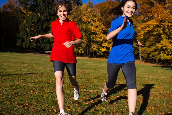 Ragazza e ragazzo correre, saltare nel parco — Foto Stock