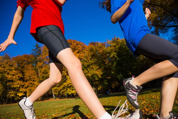 Mädchen und Junge rennen, springen im Park — Stockfoto