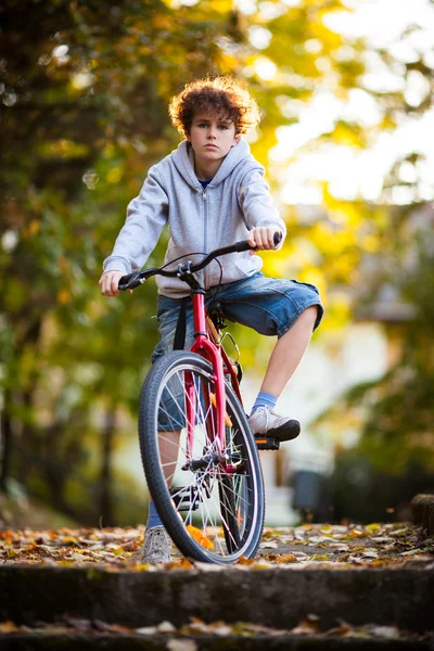 Městská cyklistika - dospívající chlapec a kolo v městském parku — Stock fotografie