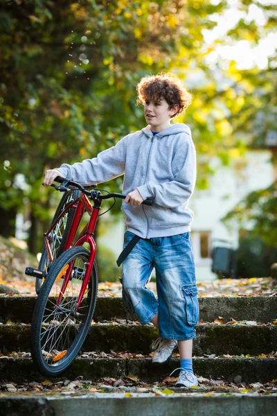 Městská cyklistika - dospívající chlapec a kolo v městském parku — Stock fotografie