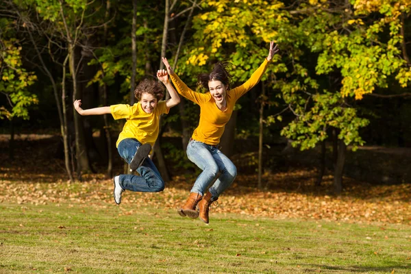 Menina e menino correndo, pulando no parque — Fotografia de Stock