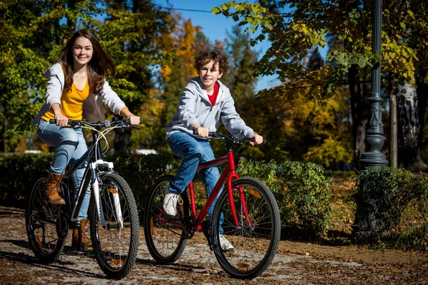 Ciclismo urbano - adolescentes montando bicicletas en el parque de la ciudad — Foto de Stock