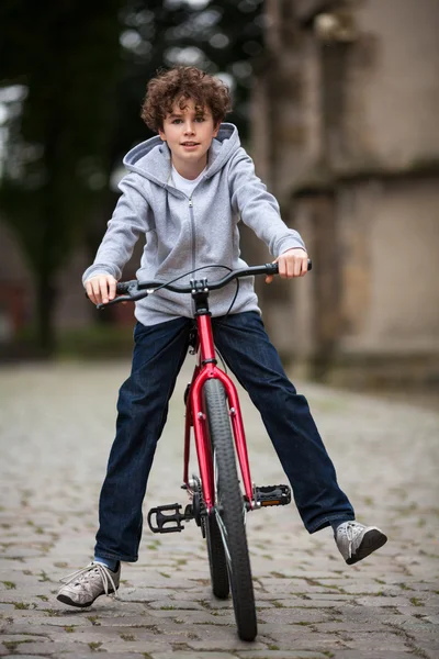 Rowery miejskie - nastoletni chłopiec i rower w mieście — Zdjęcie stockowe