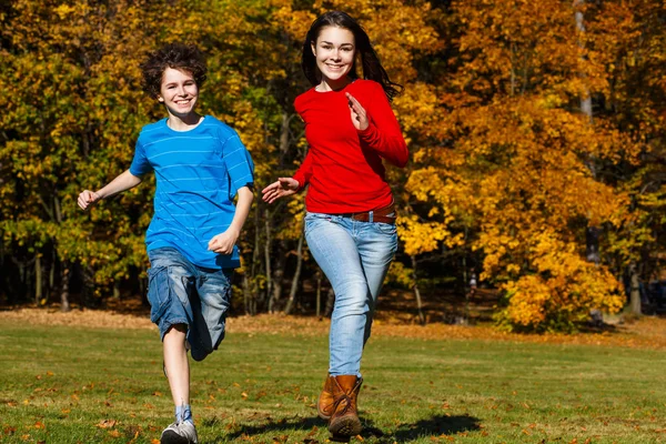 Meisje en jongen lopen, springen in park — Stockfoto