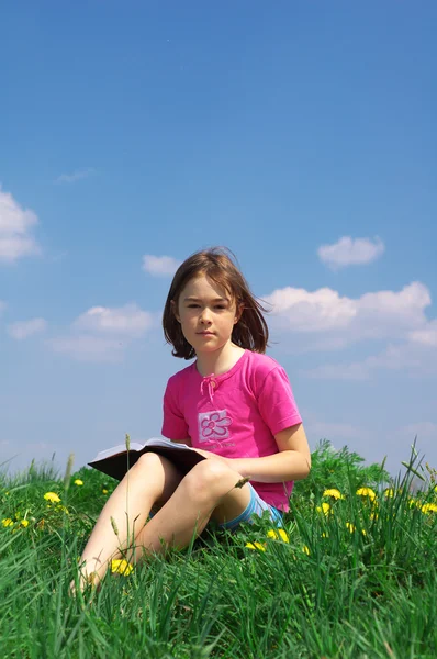 Ung flicka läser en bok — Stockfoto