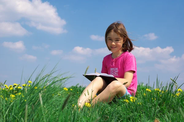 Mladá dívka čte knihu — Stock fotografie