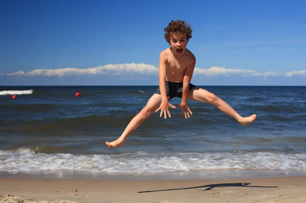 Pojke leker på stranden — Stockfoto