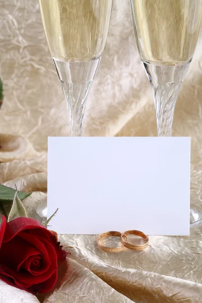 Dois copos de champanhe e anéis de casamento — Fotografia de Stock