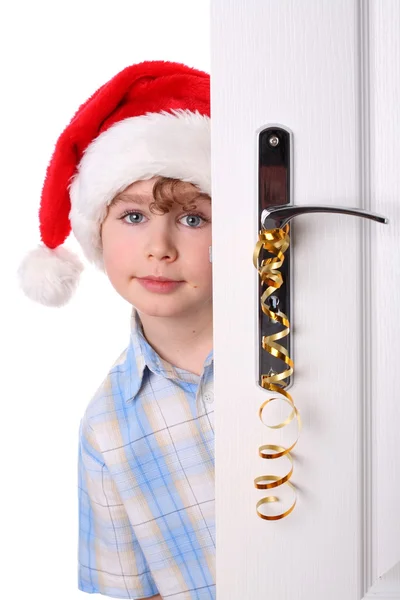 Fiú Mikulás kalapját less az ajtó mögött — Stock Fotó
