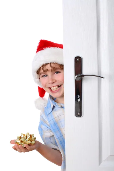 Menino com Chapéu de Papai Noel espreitando atrás da porta — Fotografia de Stock