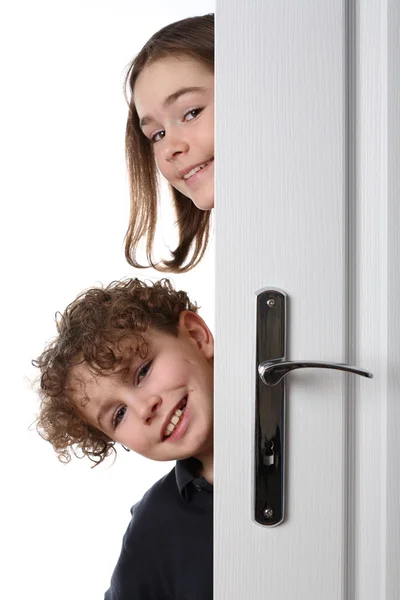 Kinderen gluren achter de deur — Stockfoto