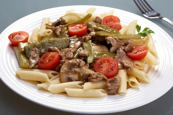 Pasta and roast meat with vegetables — Stock Photo, Image