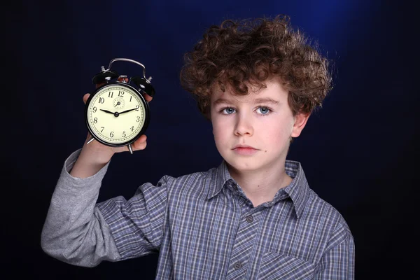Мальчик держит будильник — стоковое фото