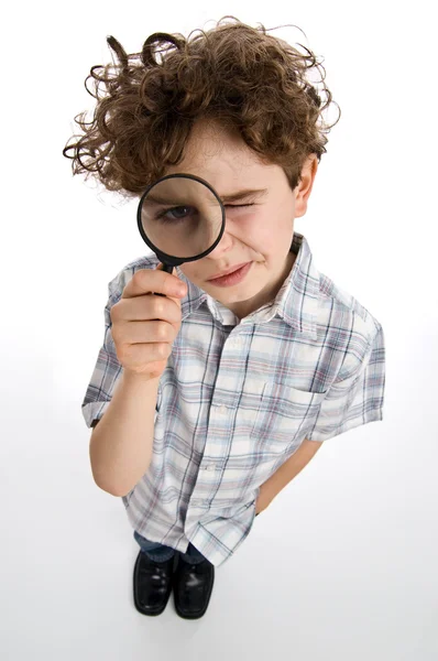 Chlapec se dívá skrz lupu — Stock fotografie