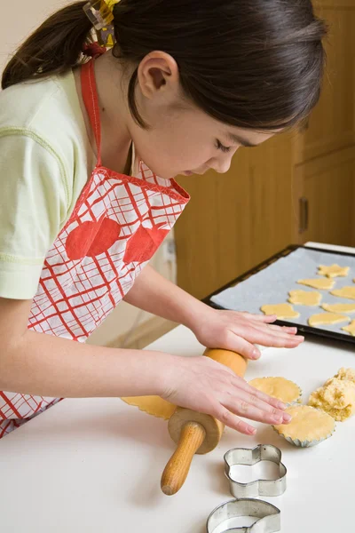 Menina jovem cozinhando biscoitos — Fotografia de Stock