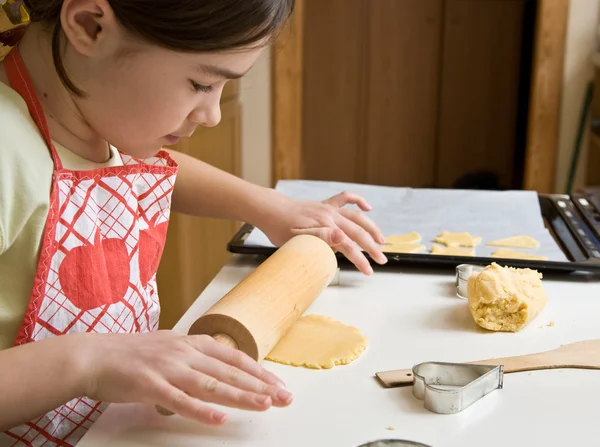 Menina jovem cozinhando biscoitos — Fotografia de Stock