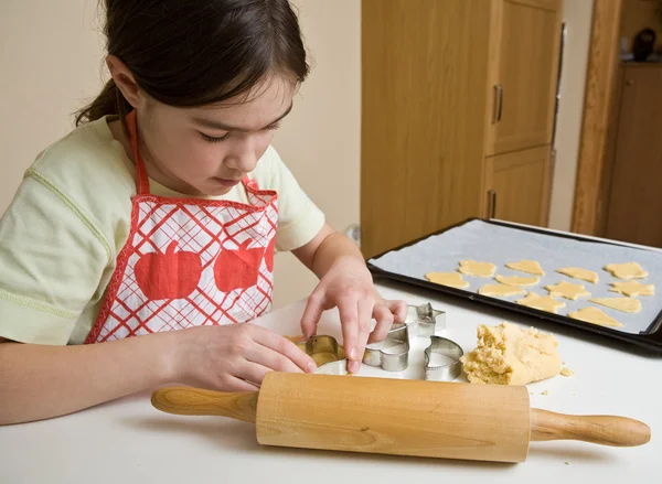 Menina jovem cozinhando biscoitos — Fotografia de Stock