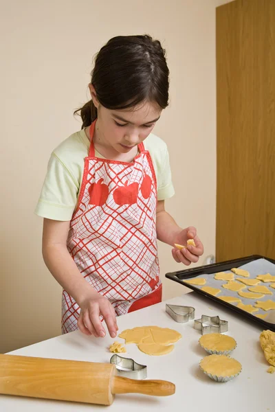 Jong meisje bakken cookies — Stockfoto