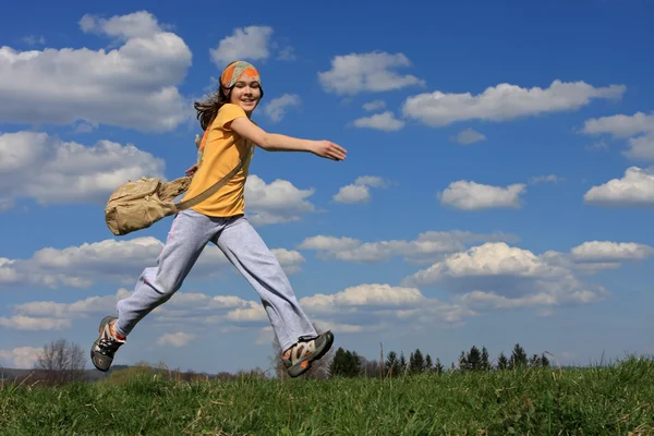 Ragazza che corre sul prato verde contro il cielo blu — Foto Stock