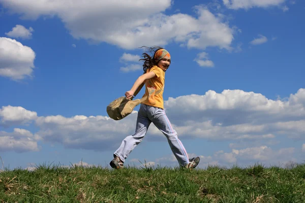 Dziewczyna pracuje na zielonej łące przeciw błękitne niebo — Zdjęcie stockowe