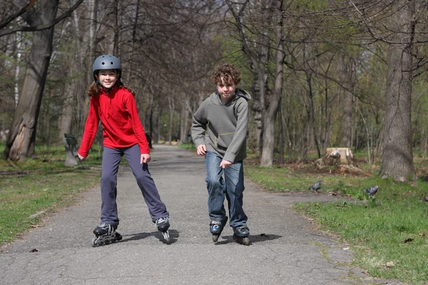 Jong meisje en jongen op roller blades — Stockfoto