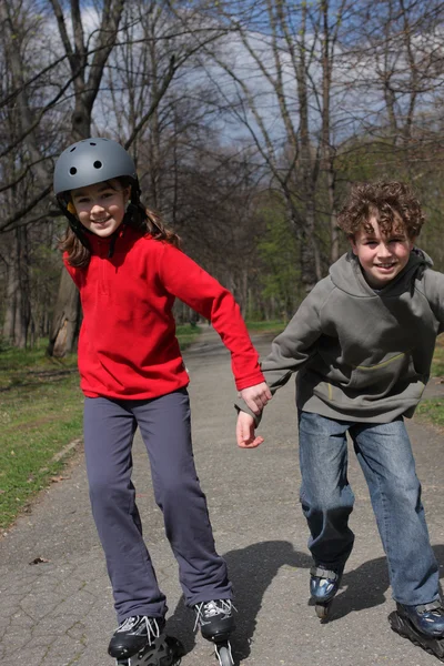 Jong meisje en jongen op roller blades — Stockfoto