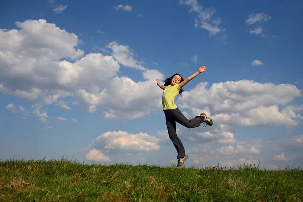 Meisje springen op groene weide — Stockfoto