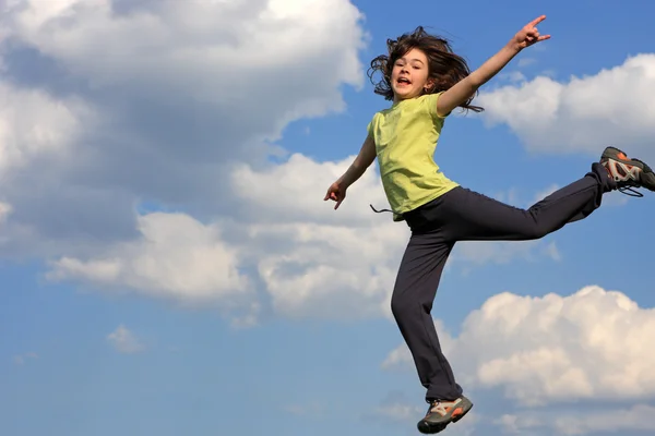 Chica saltando en pradera verde — Foto de Stock