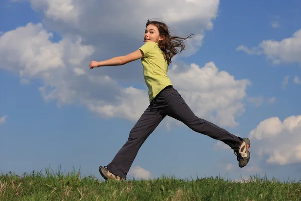 Mädchen springt auf grüne Wiese — Stockfoto