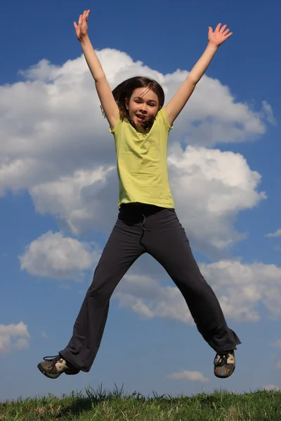 Девушка прыгает по зеленому лугу — стоковое фото