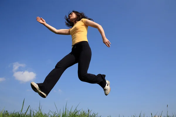 Girl jumping on green meadow — Stock Photo, Image