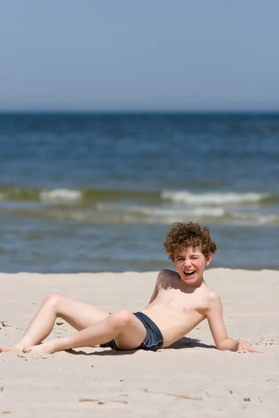 Pojke leker på stranden — Stockfoto