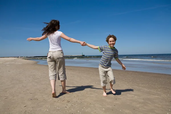 Mor och son spelar på stranden — Stockfoto