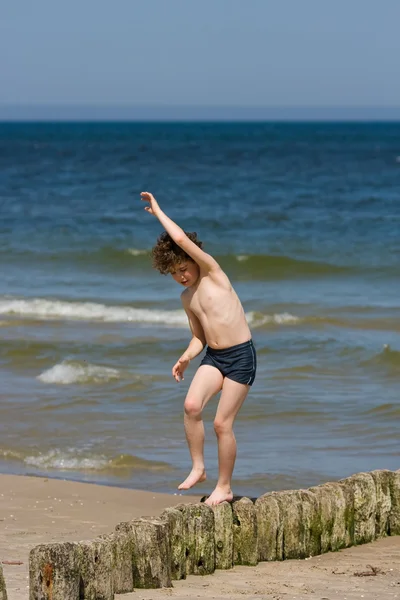 Pojken hoppar på stranden — Stockfoto