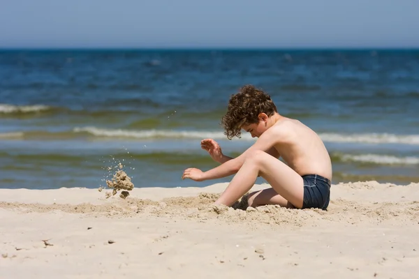 Pojke leker på stranden — Stockfoto